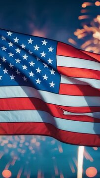 Vertical video: Fluttering American flag reacting to fireworks bursts under dark sky at waterfront