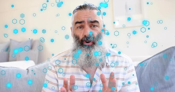 Man starting marketing talk on couch, framing widening and gesturing while blue hexagons drifting