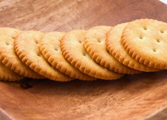 Golden round cheese crackers lined up on a wooden surface
