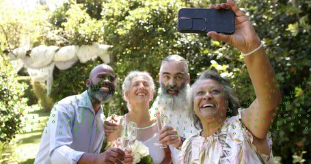 Woman moving phone into frame wedding group raising flutes taking selfie with green code over group - Powered by Adobe