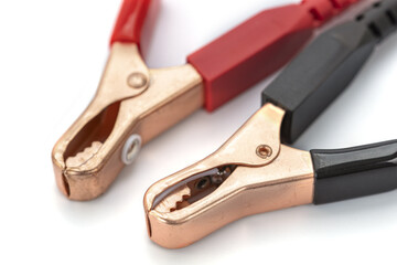 Close up of two alligator clips with red and black handles on white background, used for electrical connections. metal clamps are open, showing their teeth