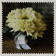 Postage stamp featuring a fresh bouquet of yellow flowers in a simple vase on a textured surface