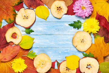 background of autumn leaves and flowers yellow, red on a wooden background and a place for writing