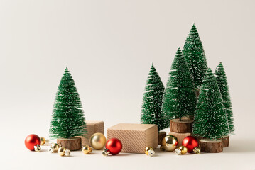 Winter forest inspired Christmas scene with miniature pine trees, ornaments and wooden blocks for product display. Ideal holiday mockup for seasonal branding and advertising.
