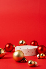Christmas product presentation scene made with round podium and ornaments on red background - elegant festive mockup for product, gift, and holiday display. Vertical photography.