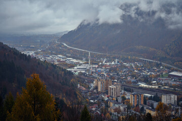 remote mountain village nestled in valley with foggy peaks and vibrant autumn colors