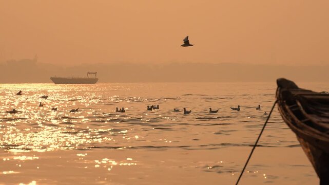 A flock of birds glides smoothly over the calm Ganga River in Kashi during early morning light, symbolizing serenity, devotion, and timeless beauty.