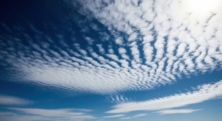Altocumulus clouds with a distinct wave pattern against a deep blue sky. Mackerel sky on a bright sunny day. Natural weather and atmospheric background
