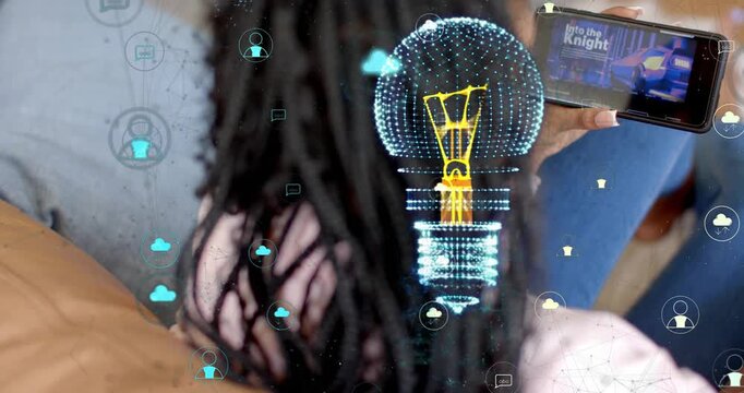 Woman on couch holding phone, swiping thumbnails and activating AR lightbulb for tech content