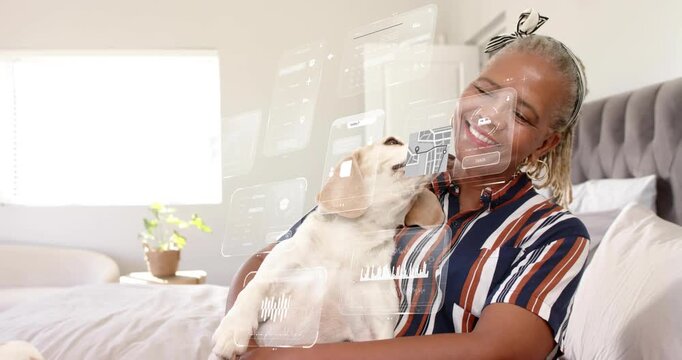 Senior woman cradling beagle, dog lifting head and licking face for affection, tech panels floating
