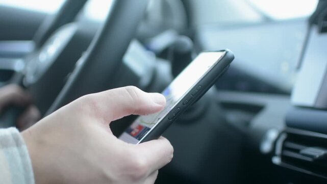Driver dangerously uses smartphone while driving, diverting attention from road and increasing risk of accident.