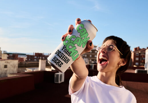 Mockup of large Blank Can in Hand and Sunlight Shining standing on a rooftop.