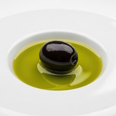 Single Black Olive Floating in Vibrant Green Olive Oil.