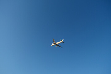 Airplane in the blue sky. A flying plane not far from the airport.