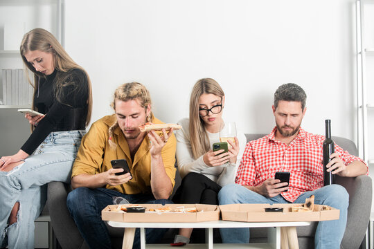 Friends sit together but all look at their phones. Group friends with social media concept. Group of people disconnected. Friends absorbed in devices. Technology silent distance.