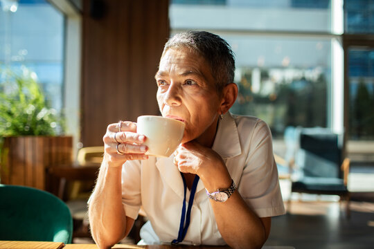 Senior woman sipping coffee thoughtfully in a cafe