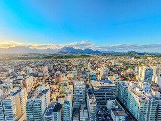 Imagem aérea da Praia do Morro em Guarapari, ao fundo mostrando a o por do sol, o centro da cidade, a ponte e o bairro do Itapebussu.