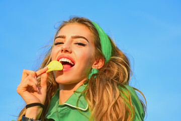 Chips food advertising concept. Snack brand lifestyle photo. Woman eating chips outdoor. Tasty and...