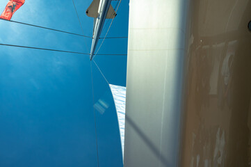 View of yacht mast from below with Albanian flag against the sky
