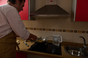 Father Cooking Dinner In Modern Kitchen While Little Girl Helps With Wok Stir Fry