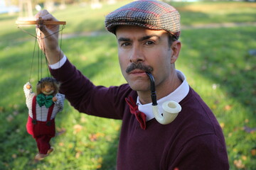 Elegant vintage puppeteer looking at his puppet 
