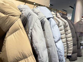 New season down jackets hanging in row. © Kassandra