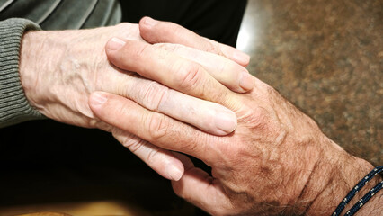Fototapeta premium A man and an elderly man hold hands. The scene is warm, comforting, and reflects love and understanding.