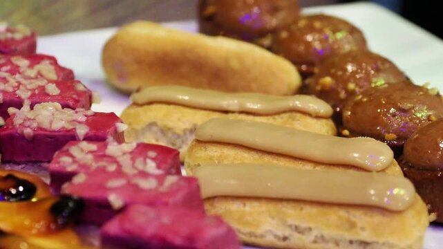 Assortiment de p&acirc;tisseries fran&ccedil;aises &mdash; &eacute;clairs au caf&eacute; et choux au chocolat &mdash; servis sur un buffet de mariage &eacute;l&eacute;gant et gourmand.
