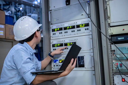 Electrical engineer male checking voltage at the Power Distribution Cabinet in the control room,preventive maintenance Yearly,inspecting power system and control panel in industrial factory - Powered by Adobe