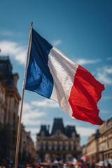 French flag waves proudly against a blue sky during Bastille Day highlighting patriotism and celebration