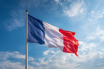 French flag waves proudly against a blue sky during Bastille Day highlighting patriotism and celebration