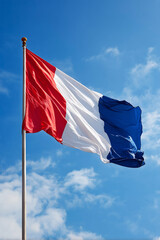French flag waves proudly against a blue sky during Bastille Day highlighting patriotism and celebration