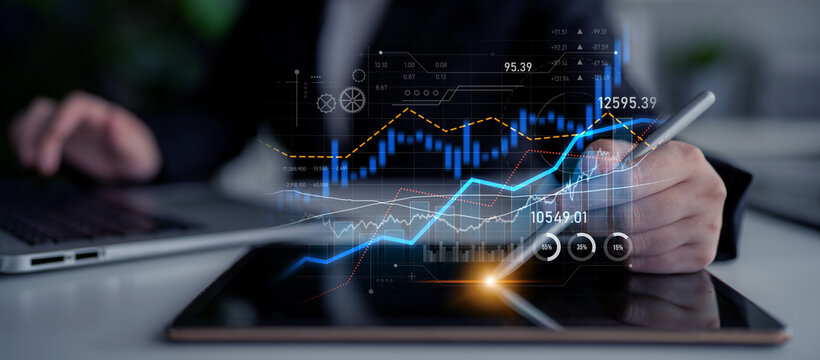 A businessperson examines financial graphs on a tablet, with digital analytics overlay. This modern setup enhances data-driven decision-making in a corporate environment. Scalp - Powered by Adobe