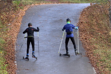 Roller skaters climb a hill on a track in the park