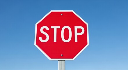 Obraz premium Red stop sign with white border and text against a clear blue sky