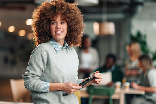 Businesswoman holding phone in creative modern office