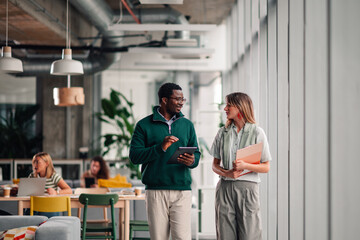 Business colleagues discussing work walking in modern office
