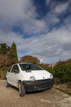 White Renault Twingo  Compact Car On A Country Road With Autumn Trees And Clear Sky
