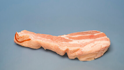 Close up of a piece of bacon on light green background.