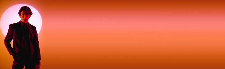 Sunset silhouette of a young stylish man in sophisticated fashion attire