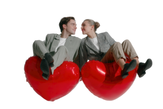 Couple floating with red heart balloons, romantic surreal collage with black and white couple and vivid red balloons