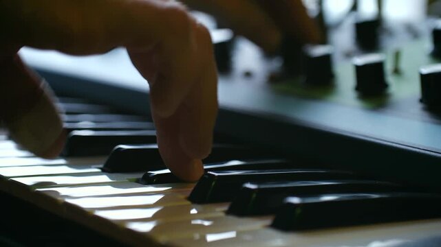 performing with synthesizer, live keyboard play creating soundscapes, hands manipulate synth controls for ambient effects, crafting atmospheric textures through finger movements on synthesizer panels