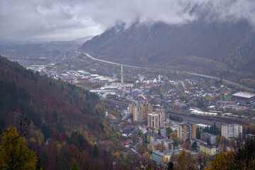 remote mountain village nestled in valley with foggy peaks and vibrant autumn colors