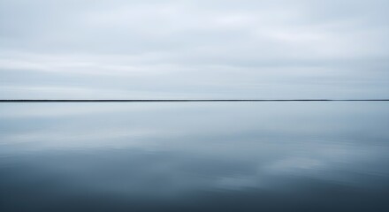 Tranquil water surface reflecting overcast sky minimalist abstract