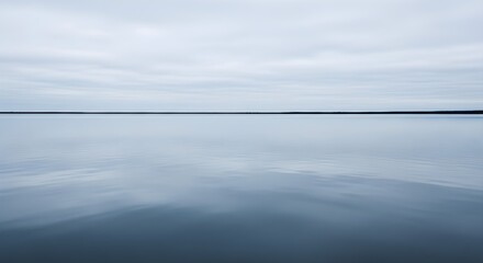 Tranquil water surface reflecting overcast sky minimalist composition