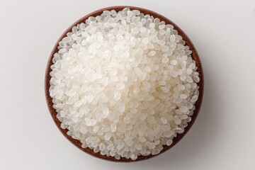 A bowl of uncooked white rice grains close up view