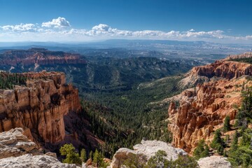 Vast canyon landscape under blue sky with dramatic rock formations