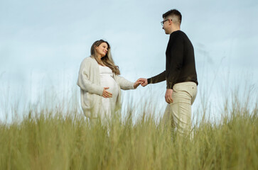 mulher grávida de mãos dadas com o marido, olhar apaixonado e feliz