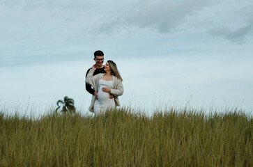 casal jovem esperando um bebê, ensaio de gestante, fotos no campo