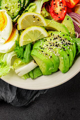 Avocado salad egg, tomato, onion, green leaf salad vegetable dish natural tasty snack fresh gourmet food background on the table rustic top view copy space keto and paleo diet vegan and vegan food